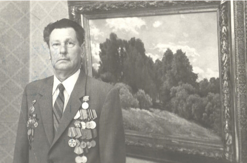 Ю.И. Петров на фоне картины И.И. Шишкина «Полянка». 1980-е гг.